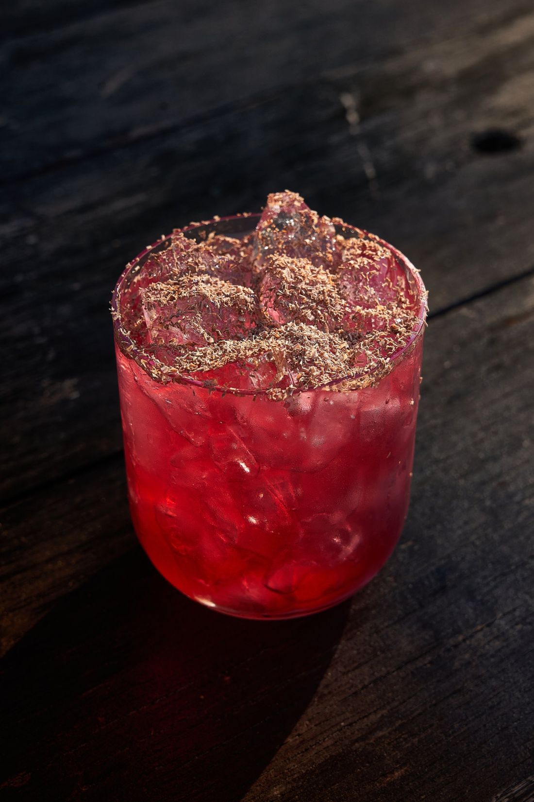 Cocktail rosso con ghiaccio e scaglie di cioccolato