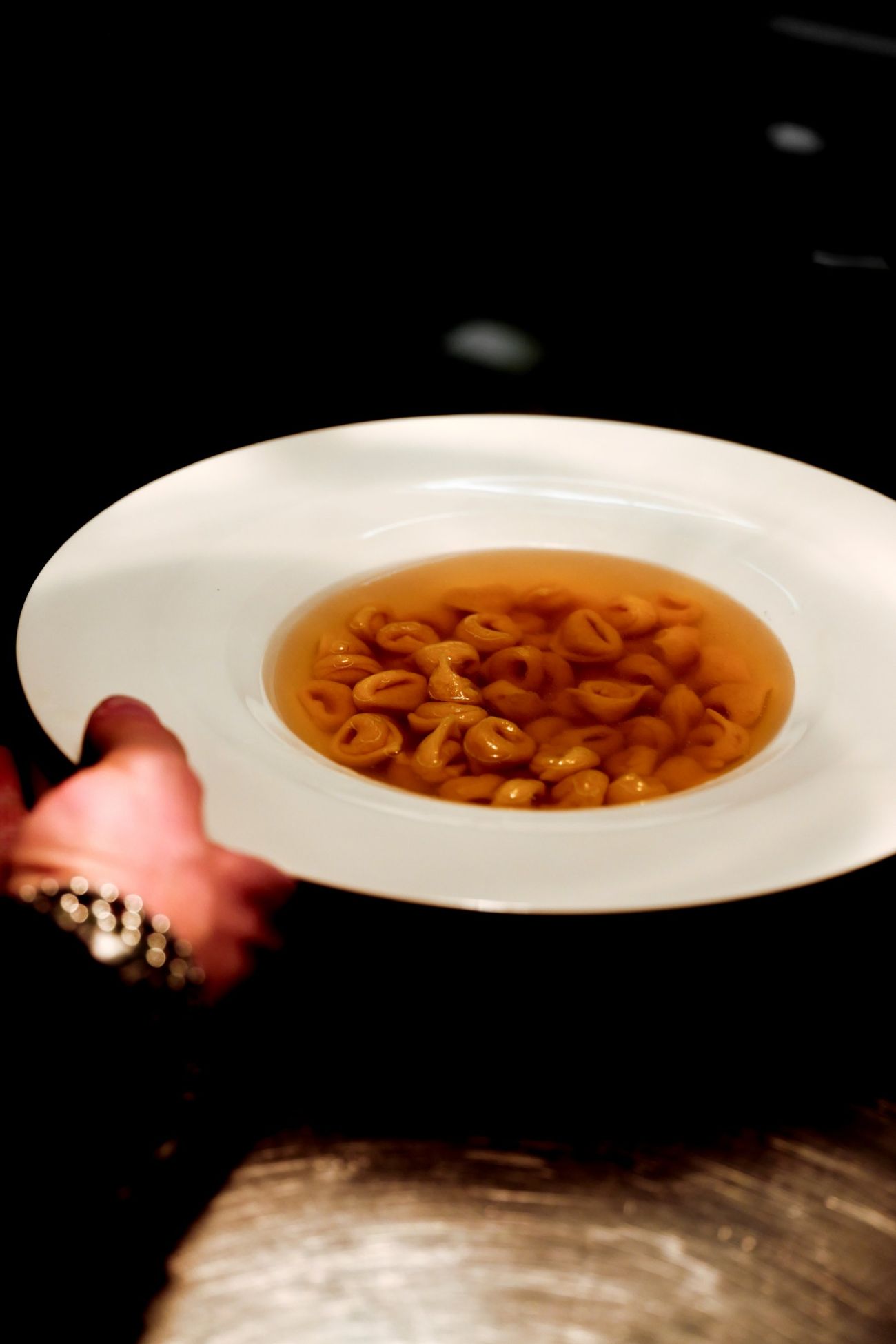 Tortellini in brodo serviti in un piatto fondo bianco